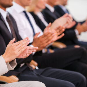 Great success. Group of business people clapping hand while sitting in a row