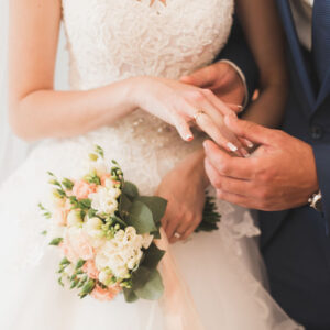 Bride and groom exchanging wedding rings. Stylish couple official ceremony.